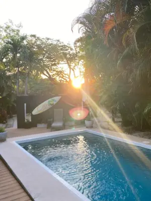 a swimming pool with a surfboard next to a house at Cote Pacific Casitas in Huacas