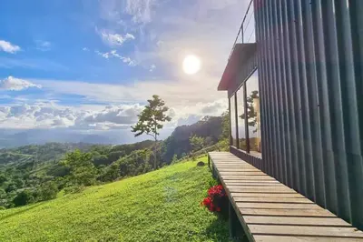 a house on a hill with a wooden porch at Alto Luciérnaga in Guayacán