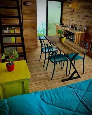 a wooden table and chairs in a room with a kitchen at Alto Luciérnaga in Guayacán
