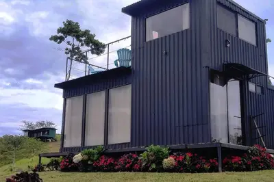 a black house with flowers in front of it at Alto Luciérnaga in Guayacán