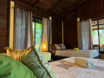 a bedroom with two beds and a window at Casita Lidia Bijagua in Bijagua