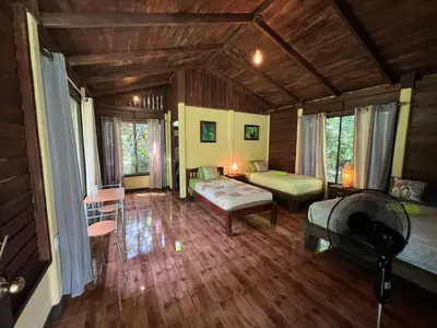 a bedroom with a bed and a couch in a room at Casita Lidia Bijagua in Bijagua