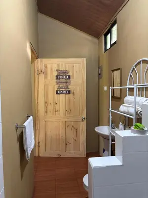 a bathroom with a wooden door and a sink at OXÍGENO Río Celeste in Bijagua