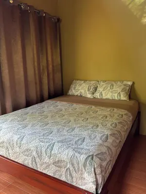 a bed in a bedroom with a bedspread and curtains at OXÍGENO Río Celeste in Bijagua
