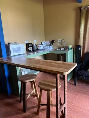 a wooden table with two stools and a microwave at OXÍGENO Río Celeste in Bijagua