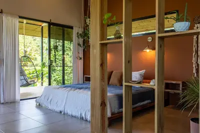 a bedroom with a bunk bed and a large window at Private Casita Jungle Treehouse Ocean View in Uvita
