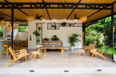 a patio with wooden tables and chairs and plants at Villas Almendros in Santa Teresa Beach