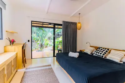 a bedroom with a large bed and a balcony at Villas Almendros in Santa Teresa Beach