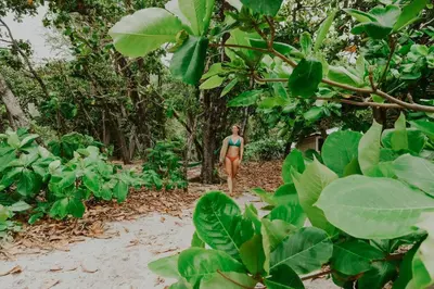 a woman walking down a path in the jungle at Villas Almendros in Santa Teresa Beach