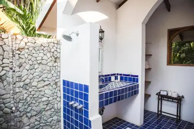 a bathroom with a shower with blue tile at Villas Almendros in Santa Teresa Beach