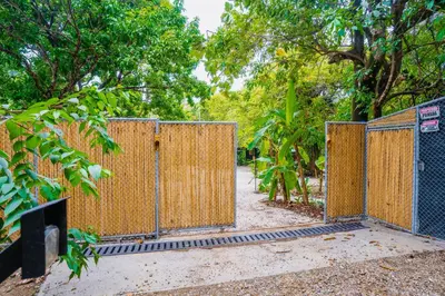 an open gate in a park with trees at Villas Almendros in Santa Teresa Beach