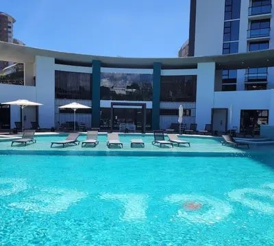 a swimming pool with chairs and umbrellas in a building at Nucleo 514 in San José