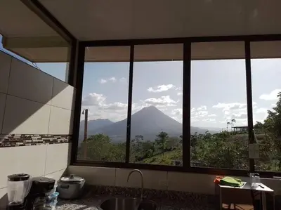 a kitchen with a view of a mountain through a window at Villas Altos del Arenal in Fortuna