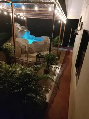 a swimming pool in a building with a fake waterfall at Villas Altos del Arenal in Fortuna