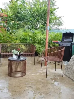 a patio with two chairs and a table and a grill at Villas Altos del Arenal in Fortuna
