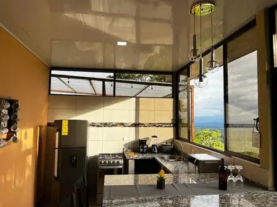 a kitchen with a large window and a counter top at Villas Altos del Arenal in Fortuna