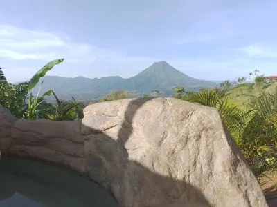 a large rock with a mountain in the background at Villas Altos del Arenal in Fortuna