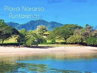 an island in the water with trees and mountains in the background at La Perla Negra Eco Pirate Resort in Puntarenas