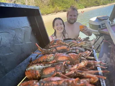 a man and a woman standing next to a large lobster at La Perla Negra Eco Pirate Resort in Puntarenas