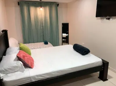 a bedroom with a bed with pillows on it at Department H González 2 in Alajuela City