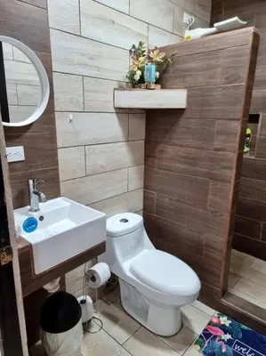 a bathroom with a white toilet and a sink at Department H González 2 in Alajuela City