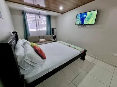 a bedroom with a bed with a tv on the wall at Department H González 2 in Alajuela City