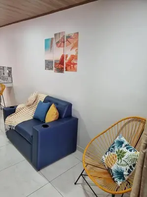 a living room with a blue couch and a chair at Department H González 2 in Alajuela City