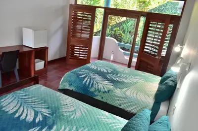 a bedroom with two beds and a window at Hotel Planeta Sano in Manuel Antonio