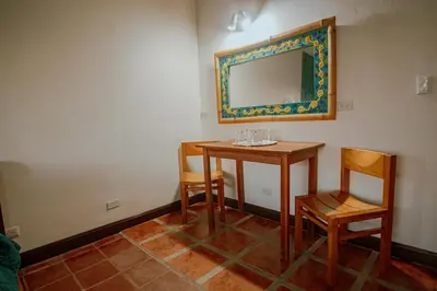 a room with a table and two chairs and a mirror at Hotel Planeta Sano in Manuel Antonio