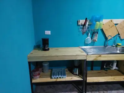 a kitchen counter with a sink and a blue wall at Residencia las brisas Griegas in Quepos