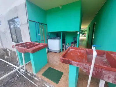 a bathroom with a red sink and green walls at Residencia las brisas Griegas in Quepos