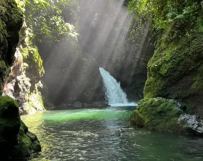 a waterfall in front of a river with green water at Casa Esperanza in Río Cuarto