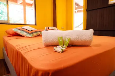 a orange bed with a towel on top of it at Miles Away in Cóbano