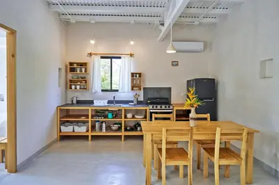 a kitchen with a wooden table and wooden chairs at Casas Teresa Mar in Santa Teresa Beach