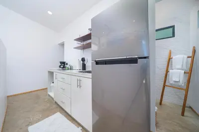 a stainless steel refrigerator in a white kitchen at L'Avventura in Tamarindo