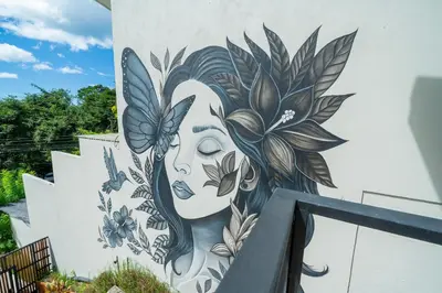 a mural of a woman with flowers on a wall at L'Avventura in Tamarindo