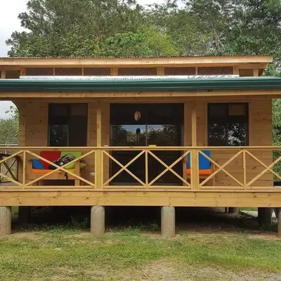 a large wooden house with some chairs in it at Villa Cola de Ballena Uvita in Uvita
