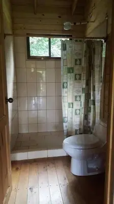 a small bathroom with a toilet and a shower at Villa Cola de Ballena Uvita in Uvita