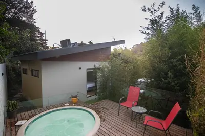 a patio with a hot tub and chairs and a house at Gamai Full House Monteverde in Monteverde Costa Rica
