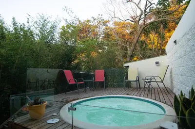 a swimming pool on a deck with chairs and a table at Gamai Full House Monteverde in Monteverde Costa Rica