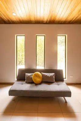 a large bed in a room with three windows at Gamai Full House Monteverde in Monteverde Costa Rica