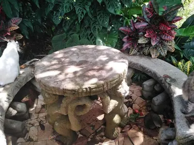 a stone stool sitting on the ground in a garden at Eco Villas Tambor Tucanes in Tambor