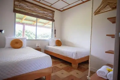 a bedroom with two beds and a swing at Buen Camino Hotel, San Mateo in San Mateo