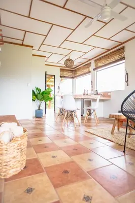 a living room with a tile floor and a ceiling at Buen Camino Hotel, San Mateo in San Mateo