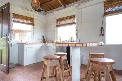 a kitchen with wooden stools and a counter top at Buen Camino Hotel, San Mateo in San Mateo
