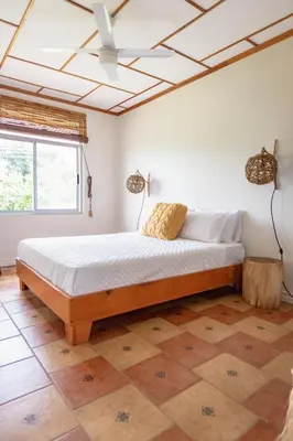 a bedroom with a large bed with a ceiling at Buen Camino Hotel, San Mateo in San Mateo