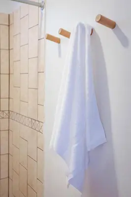 a white towel hanging on a rack in a bathroom at Buen Camino Hotel, San Mateo in San Mateo