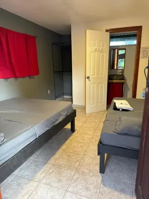 a bedroom with two beds and a door to a kitchen at CASA FOTR LOCO in Uvita