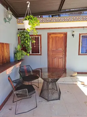 a glass table and chairs in front of a door at CASA FOTR LOCO in Uvita