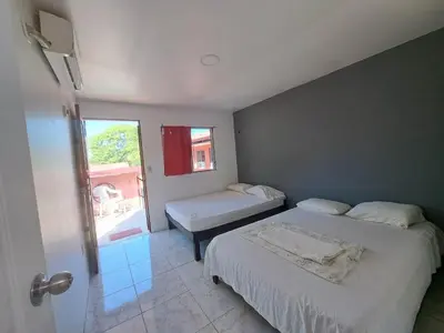 a small bedroom with two beds and a window at CASA FOTR LOCO in Uvita